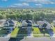 An aerial view of a suburban home in a residential neighborhood near a lake and green spaces at 10219 Lenox St, Clermont, FL 34711