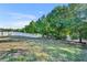 Large backyard with healthy green lawn, mature trees, and white vinyl fence on a sunny day at 10219 Lenox St, Clermont, FL 34711