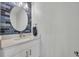 Stylish half bathroom with a blue accent wall, modern fixtures, and a round mirror at 10219 Lenox St, Clermont, FL 34711