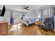 Sun-drenched bedroom featuring wood floors, a bed, and a comfortable chair at 10219 Lenox St, Clermont, FL 34711