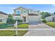 Charming two-story home with a well-manicured lawn and a brick paved driveway at 10219 Lenox St, Clermont, FL 34711