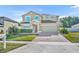 Charming two-story home with a well-manicured lawn and a brick paved driveway at 10219 Lenox St, Clermont, FL 34711