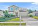 Charming two-story home with a well-manicured lawn and a brick paved driveway at 10219 Lenox St, Clermont, FL 34711