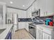 Updated kitchen features modern appliances, white cabinetry, and stylish blue tiled backsplash at 10219 Lenox St, Clermont, FL 34711