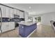 Open kitchen with stainless steel appliances, blue backsplash, and a large island with a built-in sink at 10219 Lenox St, Clermont, FL 34711
