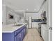 Updated kitchen with white cabinets, blue backsplash, stainless steel appliances, and a central island sink at 10219 Lenox St, Clermont, FL 34711