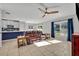 Bright living room featuring a leather sofa, tile floors, and large windows with blue curtains at 10219 Lenox St, Clermont, FL 34711