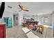 Open-concept living room with ceiling fan, tile floors, and view into the modern white kitchen at 10219 Lenox St, Clermont, FL 34711