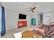 Comfortable living room featuring a ceiling fan, television, and views of the staircase at 10219 Lenox St, Clermont, FL 34711
