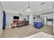 Open-concept living space with kitchen island, comfortable seating, and a large television at 10219 Lenox St, Clermont, FL 34711