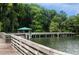 Scenic waterfront view with a wooden boardwalk leading to a covered gazebo surrounded by lush greenery at 110 N Tremain St # 205, Mount Dora, FL 32757