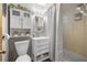 Bright bathroom featuring white vanity, toilet, and shower with tile surround and decorative fixtures at 1107 Valley Rd, Fruitland Park, FL 34731