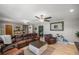 Comfortable living room featuring a leather sectional, ceiling fan, and neutral paint at 1107 Valley Rd, Fruitland Park, FL 34731