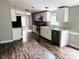 Open kitchen with stainless steel appliances, white cabinets, and wood grain flooring at 11252 Country Haven Dr, Lakeland, FL 33809