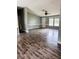 Open-concept living room with dark floors, wainscoting, and a ceiling fan for comfort at 11252 Country Haven Dr, Lakeland, FL 33809