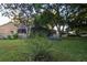 Private backyard featuring a lush lawn, mature trees, and a charming white picket fence creating a serene outdoor oasis at 11312 Haskell Dr, Clermont, FL 34711