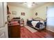 Comfortable bedroom featuring hardwood floors, a metal-framed bed, and a vintage desk area at 11312 Haskell Dr, Clermont, FL 34711