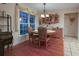 This inviting dining room features hardwood floors, a window for natural light, and a stylish chandelier above the table at 11312 Haskell Dr, Clermont, FL 34711