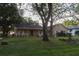 Inviting single-story home with a covered porch, mature trees, and a well-manicured lawn at 11312 Haskell Dr, Clermont, FL 34711