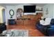 Cozy living room featuring hardwood floors, a decorative cabinet, a flat-screen television, and comfortable furnishings at 11312 Haskell Dr, Clermont, FL 34711