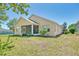 A home's backyard features a screened-in patio, surrounded by lush landscaping and a well-maintained lawn at 117 Falling Acorn Ave, Groveland, FL 34736