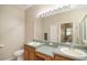 Bathroom features a large mirror, double sinks, and a toilet at 117 Falling Acorn Ave, Groveland, FL 34736