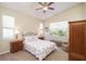 Comfortable bedroom featuring a patterned bedspread and a ceiling fan for added comfort at 117 Falling Acorn Ave, Groveland, FL 34736