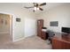 Bright carpeted bedroom featuring a ceiling fan, closet and a wooden desk setup at 117 Falling Acorn Ave, Groveland, FL 34736