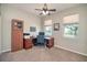 Bright carpeted bedroom featuring two windows, a cabinet and a wooden desk setup at 117 Falling Acorn Ave, Groveland, FL 34736