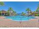 Community pool featuring a brick path and surrounded by palm trees at 117 Falling Acorn Ave, Groveland, FL 34736