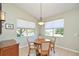 Dining area features wood table, four chairs, and natural light from two windows at 117 Falling Acorn Ave, Groveland, FL 34736