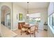 Cozy dining area with a round wooden table and natural light from the window at 117 Falling Acorn Ave, Groveland, FL 34736