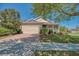 Inviting single-story home with a well-manicured lawn, mature trees and a charming front porch at 117 Falling Acorn Ave, Groveland, FL 34736