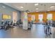 Well-equipped fitness center features modern cardio machines, ceiling fans, and large windows for a bright workout space at 117 Falling Acorn Ave, Groveland, FL 34736