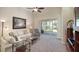 Bright living room featuring neutral decor, plush seating and sliding glass doors to the lanai at 117 Falling Acorn Ave, Groveland, FL 34736