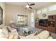 Cozy living room with a comfortable seating arrangement, a ceiling fan and sliding glass doors at 117 Falling Acorn Ave, Groveland, FL 34736