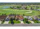 Aerial view of a residential neighborhood adjacent to a golf course and featuring mature landscaping and backyard pools at 12136 Se 176Th Loop, Summerfield, FL 34491