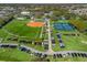Aerial view of community facilities including baseball, tennis, and a parking lot at 12136 Se 176Th Loop, Summerfield, FL 34491