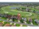 Aerial view of house on golf course featuring lush landscaping, a neutral color palette, and a red map pin at 12136 Se 176Th Loop, Summerfield, FL 34491