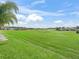 Expansive backyard featuring mature landscaping, grassy areas, and views of the adjacent golf course at 12136 Se 176Th Loop, Summerfield, FL 34491