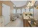Bright bathroom with double vanities, a soaking tub, and ample natural light from arched windows at 12136 Se 176Th Loop, Summerfield, FL 34491
