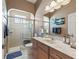 Bathroom features a walk-in shower with glass door and marble vanity at 12136 Se 176Th Loop, Summerfield, FL 34491