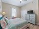 Comfortable bedroom with a patterned bedspread, soft lighting, and closet space for storage at 12136 Se 176Th Loop, Summerfield, FL 34491