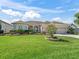 Well-maintained front yard with lush green grass, beautiful landscaping, and a spacious three-car garage at 12136 Se 176Th Loop, Summerfield, FL 34491