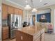 Spacious kitchen with stainless steel refrigerator, center island, and a view of the living room at 12136 Se 176Th Loop, Summerfield, FL 34491