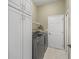 Laundry room features a washer, dryer, overhead rack, and storage cabinets at 12136 Se 176Th Loop, Summerfield, FL 34491