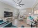 Elegant living room with comfortable seating, ceiling fan, and natural light from large windows at 12136 Se 176Th Loop, Summerfield, FL 34491