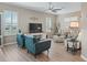 Bright living room with a ceiling fan, stylish furniture, and large windows with shutters at 12136 Se 176Th Loop, Summerfield, FL 34491