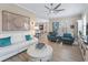 Open-concept living room with a white leather sofa, blue accents, and views of the adjacent dining area at 12136 Se 176Th Loop, Summerfield, FL 34491