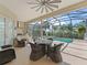 Covered patio with table, wicker chairs, ceiling fan, and built-in kitchen at 12136 Se 176Th Loop, Summerfield, FL 34491
